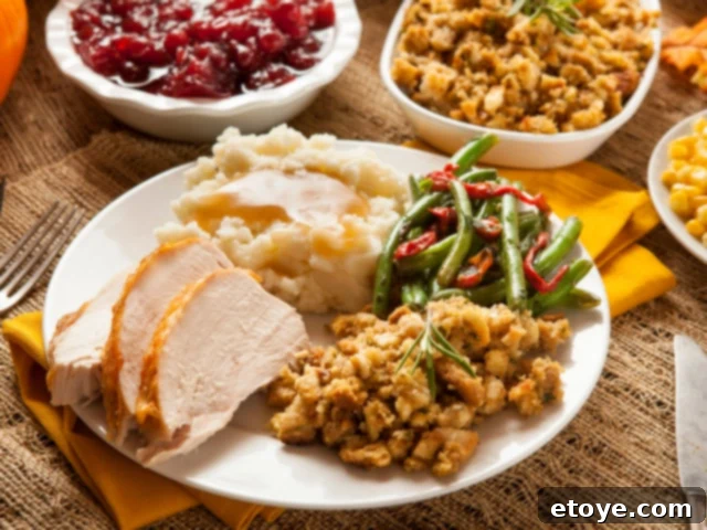 A festive Thanksgiving dinner plate with turkey, mashed potatoes, green beans, and cranberry sauce