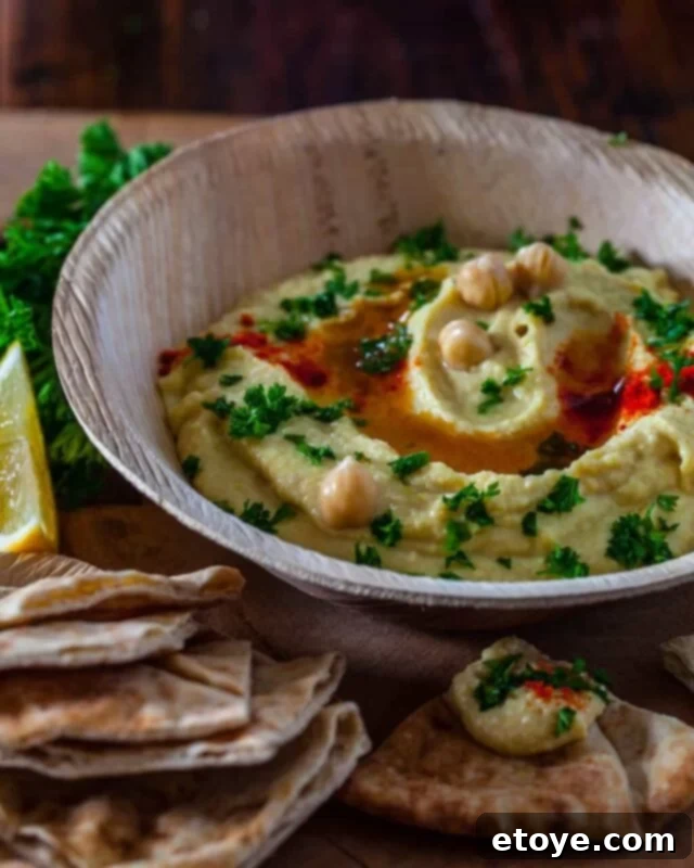 Wholesome Homemade Hummus 2 Healthy homemade hummus in a bowl, garnished with paprika and olive oil