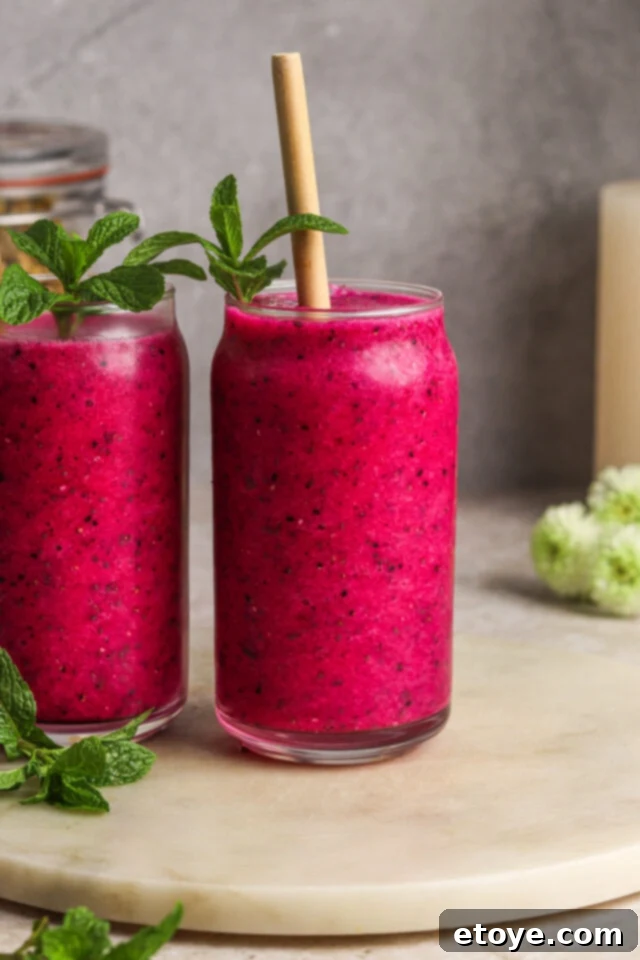 Dragon Fruit Hibiscus Coconut Refresher 7 A close-up shot of a Dragon Fruit Chill Smoothie being poured into a tall glass, highlighting its smooth, thick texture and vibrant pink color.