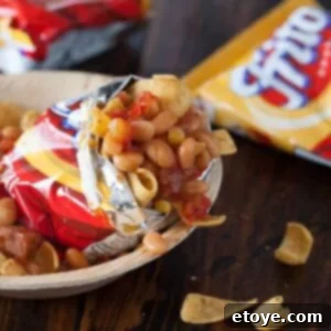 Hearty Pressure Cooker White Bean Frito Pie 2 Delicious White Bean Chili Frito Pie served in a bowl, garnished with fresh herbs, ready to be enjoyed.