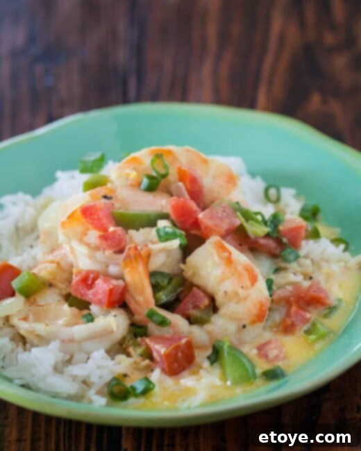A vibrant bowl of Coconut Curry Shrimp served with fluffy Coconut Rice, garnished with fresh cilantro
