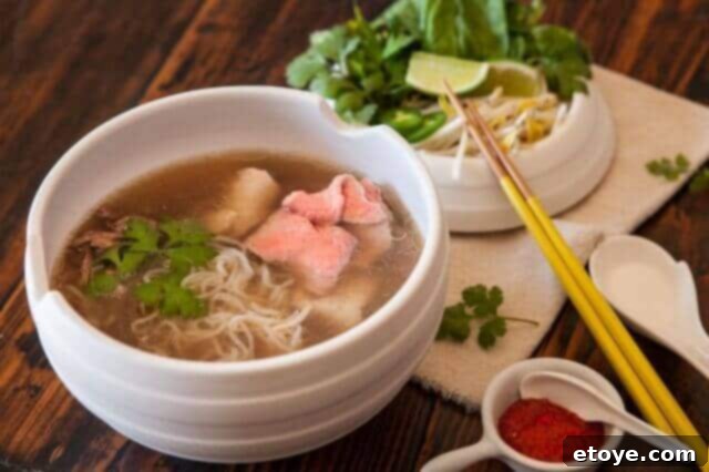 Ingredients for Vietnamese Pho laid out for preparation, highlighting fresh herbs, spices, and beef.