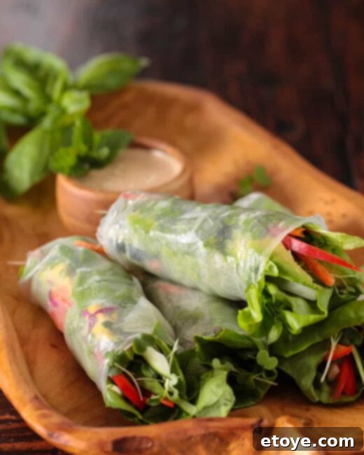 Delicious Vietnamese spring rolls with a vibrant orange almond dipping sauce, elegantly presented on a plate.