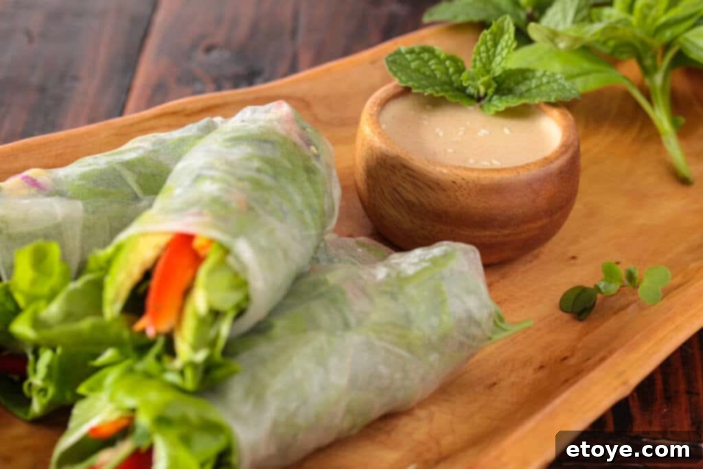 A vibrant platter of Vietnamese spring rolls and a bowl of the creamy orange almond sauce, ready for serving.