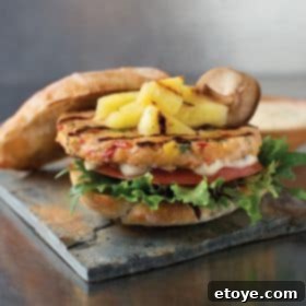 Win Omaha Steaks' Burger Trio 2 Close-up of a perfectly grilled Omaha Steaks burger with melted cheese and fresh vegetables