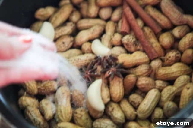 Classic Chinese Boiled Peanuts 4 Adding aromatic spices like star anise and cinnamon sticks to peanuts in a pot