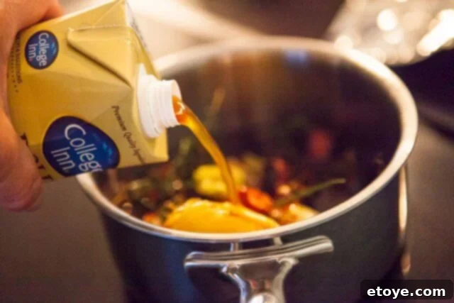 Prime Rib Roast Recipe - Adding Beef Broth Beef broth being added to the au jus in a pot