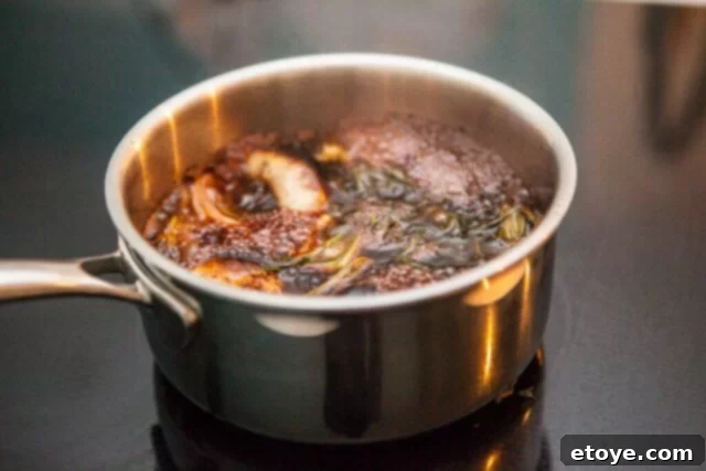 Prime Rib Roast Recipe - Simmering Au Jus Au jus simmering in a saucepan