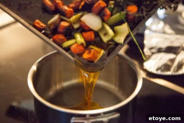 Prime Rib Roast Recipe - Making Au Jus Pouring pan drippings and vegetables into a saucepan