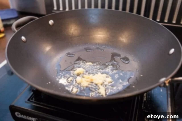 Garlic Stir-Fried Pea Shoots 4 Garlic infusing in hot oil for stir-fried pea shoots
