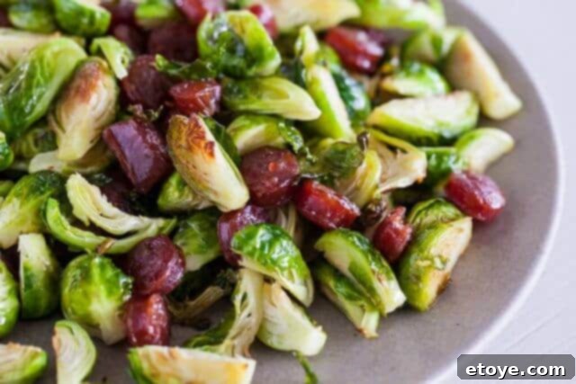 Sweet and Savory Brussels Sprouts with Lap Cheong 3 Close-up of perfectly roasted Brussels sprouts alongside sliced Chinese sausage, ready to be served.