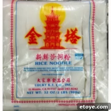 Malaysian Chicken Noodle Soup with Fresh Asian Greens and Spicy Chili Soy Sauce 3 Close-up of fresh wide rice noodles, ideal for Malaysian Chicken Noodle Soup, neatly arranged.