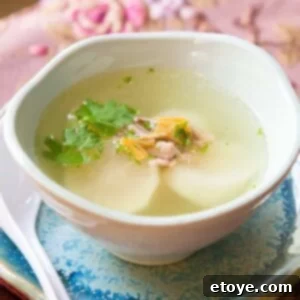 A close-up shot of the finished Chinese Daikon Soup, garnished with fresh herbs, in a recipe card context.