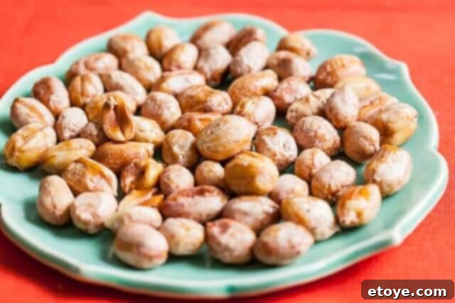 Roasted honey peanuts cooling on a baking sheet, ready for a crunchy snack.
