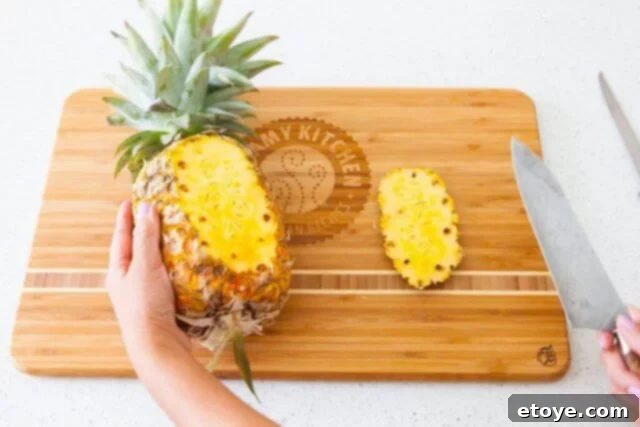 Close-up of a pineapple being prepared for a lengthwise cut, ensuring stability