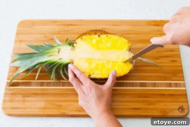 Making two parallel cuts to carefully remove the central, fibrous pineapple core
