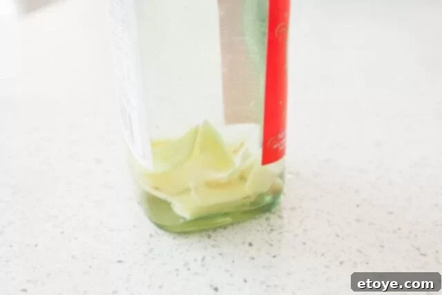 Making the Most of Leftover Ginger 4 Close-up view of ginger slices submerged in golden cooking wine, showcasing the infusion process