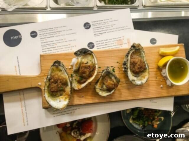 Wood-fire roasted oysters at Meril in New Orleans, showcasing a unique and savory preparation of fresh oysters.