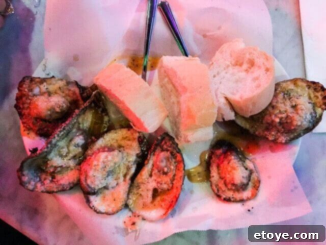 Char-grilled oysters topped with butter and Parmesan cheese, a popular and indulgent dish at Acme Oyster House.