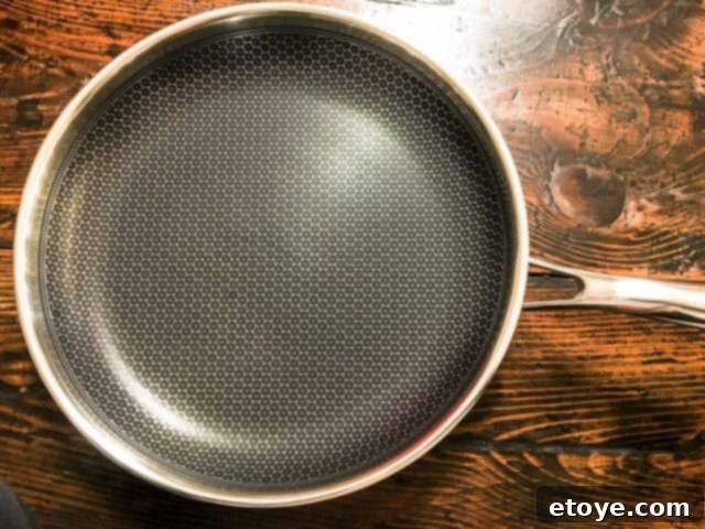 Close-up of the Frieling Black Cube Wok's interior, highlighting the raised stainless steel honeycomb pattern
