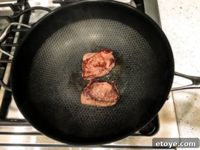 Perfectly seared steak sizzling in the Frieling Black Cube Wok on high heat