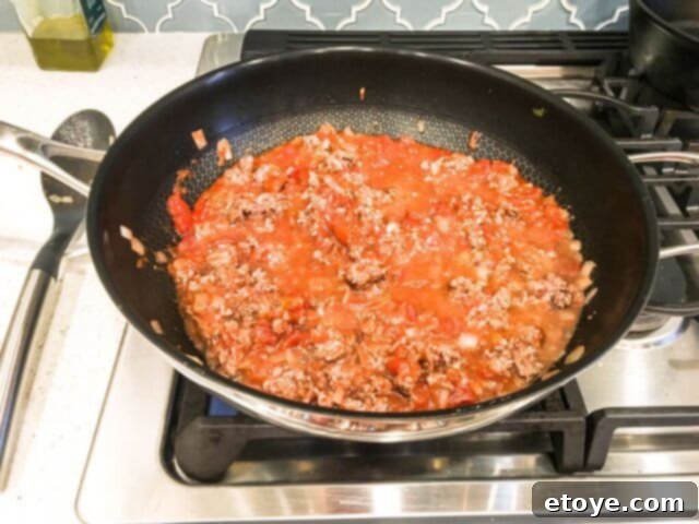 A generic dome-shaped wok lid on top of the Frieling Black Cube Wok, illustrating the necessity of a lid