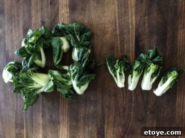 Baby bok choy, cut in half, showcasing preparation for quick and even cooking.
