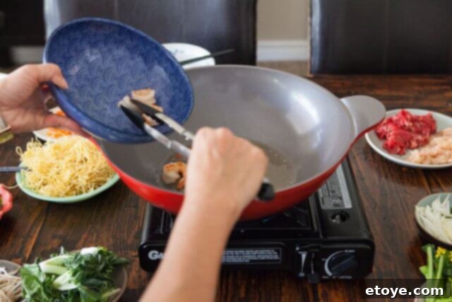 Half-cooked shrimp removed from the wok and set aside, ready to be added back later.