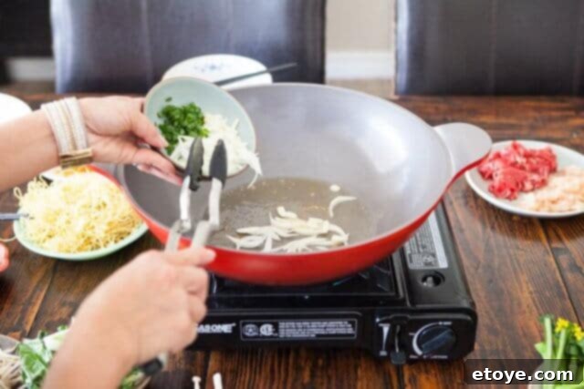 Thinly sliced onions and garlic stir-frying in a wok, releasing their fragrant aromas.