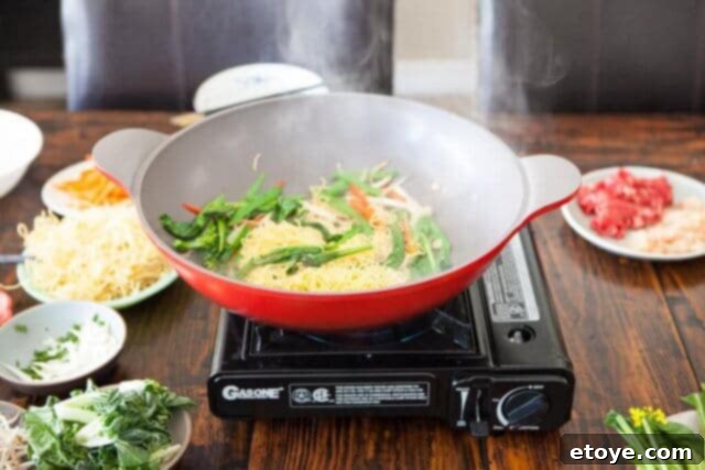 A small amount of water added to the noodles in the wok, creating steam for reheating.