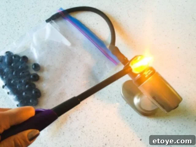 Delicious Smoked Olives Using a Smoking Gun 9 The Smoking Gun turned on, with a flame from a lighter igniting the wood chips in its chamber.