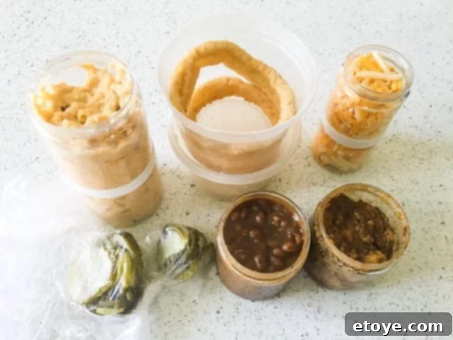 BurgaBox Review And Win 100 Dollars 6 An array of delicious sides and toppings from BurgaBox, showcasing mac 'n cheese, potato wedges, and various sauces.