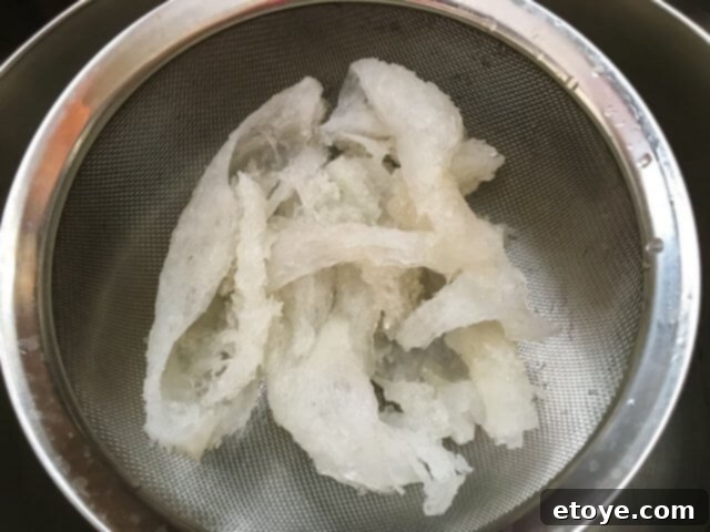 Exquisite Chinese Bird's Nest Soup 8 A cleaned and drained bird's nest resting in a sieve, ready for cooking.