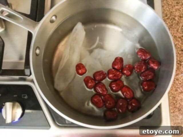 Exquisite Chinese Bird's Nest Soup 9 Dried red dates and prepared bird's nest gently simmering in a pot of water.