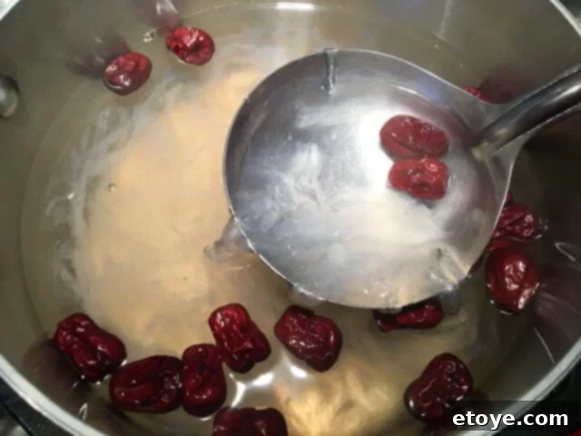 Exquisite Chinese Bird's Nest Soup 10 A ladle gently stirring the bird's nest soup, showing its gelatinous texture.