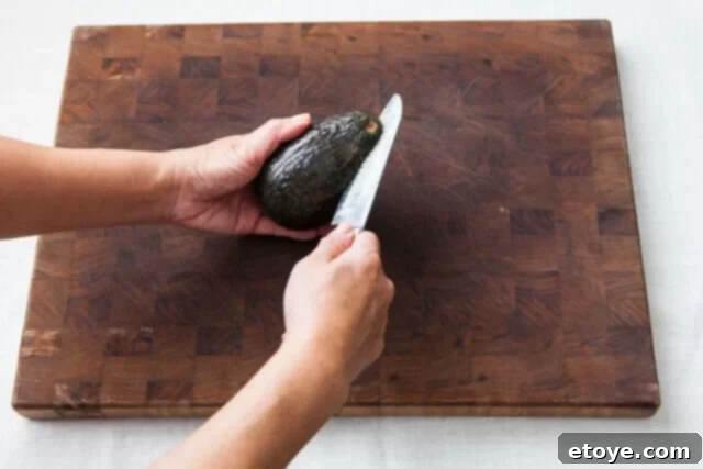 Grapefruit, Avocado and Baby Arugula Salad 12 Cutting avocado around the pit lengthwise