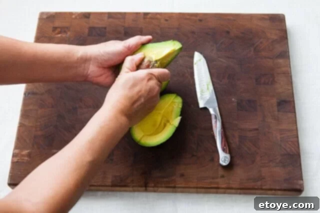 Grapefruit, Avocado and Baby Arugula Salad 16 Removing avocado pit with a spoon