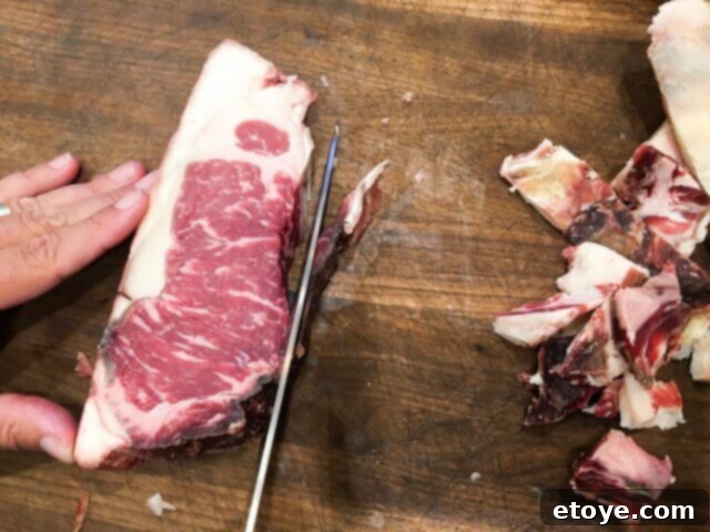 SteakAger Review Plus Win One 20 Close-up of a knife meticulously trimming the last pieces of bark from a dry-aged steak