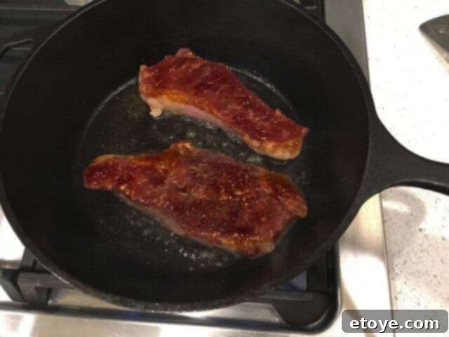 SteakAger Review Plus Win One 28 A hot cast iron pan ready for searing a steak, with oil shimmering on the surface