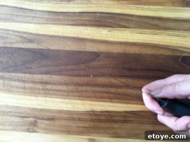 Close-up of the incredibly thin blade of a Kuhn Rikon chef's knife, demonstrating its precision.