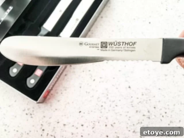 Wusthof burger knife in use, cutting a sandwich.