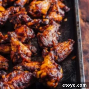 Finger Licking Oven BBQ Chicken Wings 3 Oven barbecued chicken wings on a baking sheet, glazed with homemade sauce.