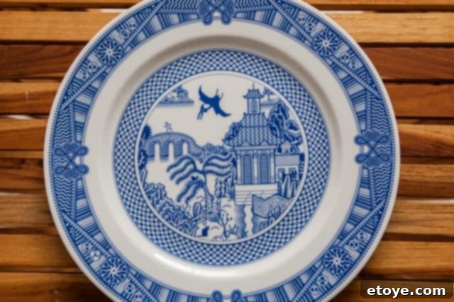 The original Calamityware plate featuring a pterodactyl within a blue-willow design, showcasing in-glaze decoration