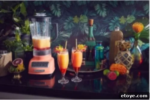 Elevate Your Kitchen Win a KitchenAid Blender 2 KitchenAid 5-Speed Diamond Blender in Bird of Paradise color, showcasing its vibrant coral hue on a kitchen counter