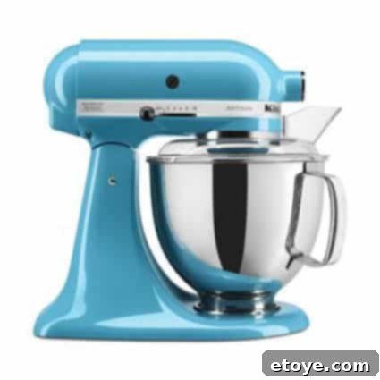 Win a KitchenAid Artisan 5-Quart Stand Mixer 2 KitchenAid Artisan Stand Mixer in a vibrant kitchen setting, showcasing its elegant design.