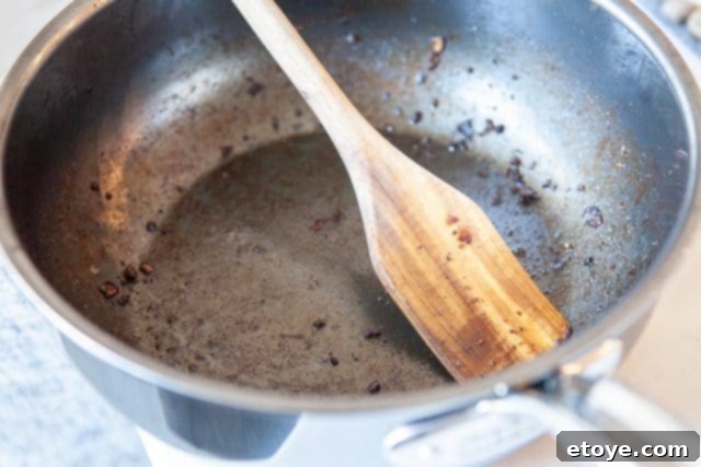 Hestan Nanobond Essential Pan Review & Giveaway 11 Hestan Nanobond Essential Pan being rinsed under running water in a kitchen sink