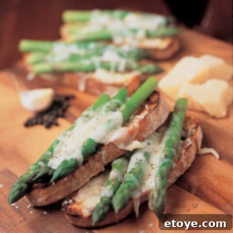 Delicious grilled bruschetta topped with tender asparagus spears and grated Parmesan cheese
