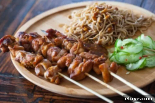 Unforgettable Chicken Creations 24 chicken satay and noodles on a wooden plate