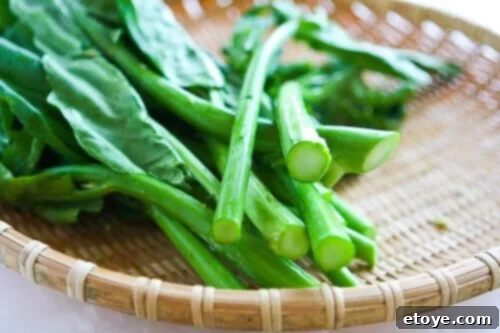 Fresh Chinese Broccoli (Gai-Lan) stems showing milky-translucent cut ends, indicating optimal freshness for stir-frying.