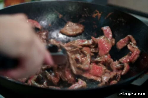 Close-up of perfectly caramelized beef slices in a wok, indicating successful stir-frying technique